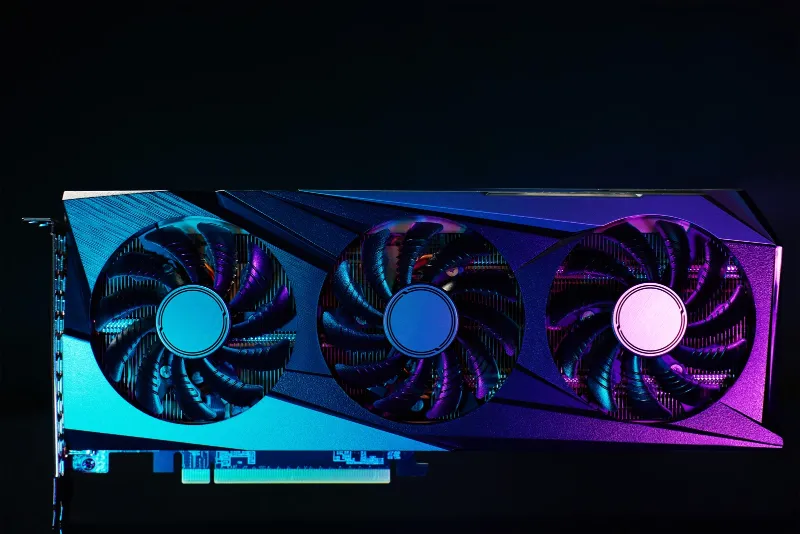 Foto de estudio de una tarjeta gráfica de tres ventiladores bajo luz azul y magenta